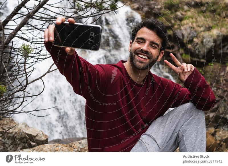 Entzückter Reisender, der ein Selfie vor einem Wasserfall macht Mann Wanderer Selbstportrait Berge u. Gebirge zwei f