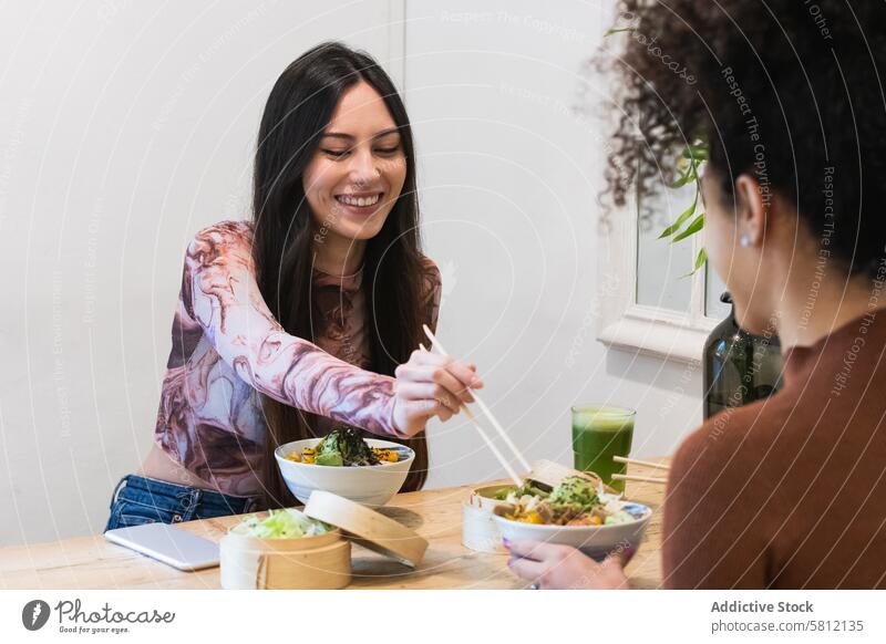 Zufriedene freundliche multiethnische Frauen beim Essen im Restaurant Freund essen Kälte stoßen Speise geschmackvoll Freundschaft Zusammensein vielfältig