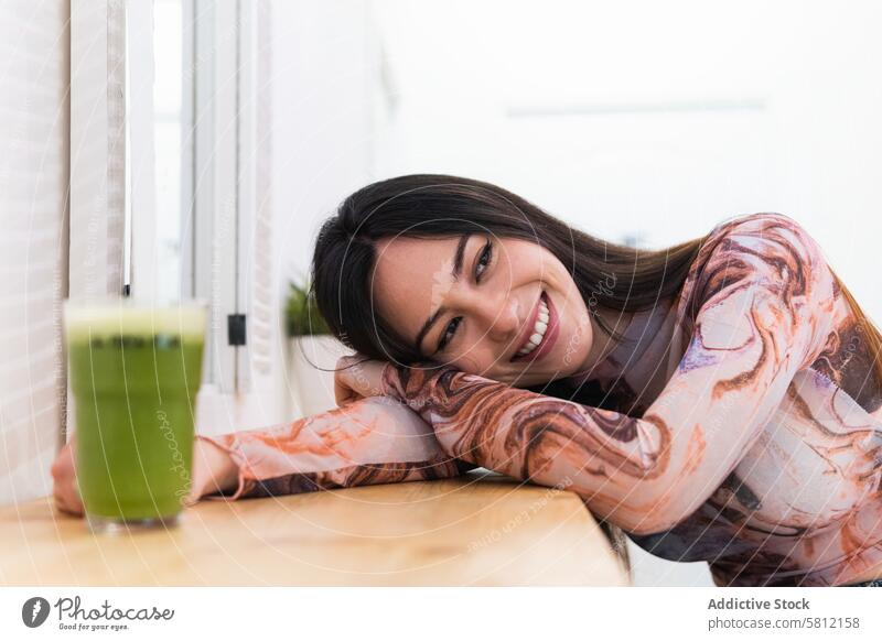 Zufriedene Frau genießt ein grünes Getränk in einer Bar Kälte Wochenende genießen Abfertigungsschalter Inhalt heiter sich[Akk] entspannen Lächeln Freude modern