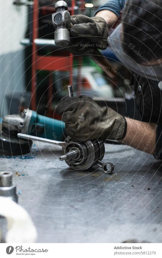 Anonymer Mechaniker, der das Kurbelwellenlager eines Motorrads in der Werkstatt repariert Mann versammeln Hammer Schacht Auto Garage Arbeit fixieren Job