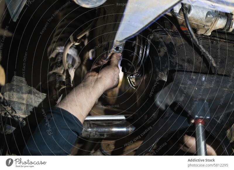 Anonymer erwachsener Mechaniker, der ein Auto auf einer Hebebühne in der Garage repariert Mann Reparatur PKW Dienst fixieren Arbeit inspizieren Flugzeugwartung