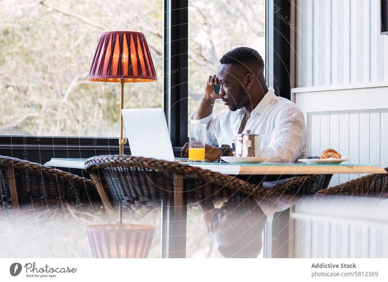 Schwarzer Mann telefoniert in einem Cafe Café Telefon reden diskutieren ernst beschäftigt Frühstück Anruf Gespräch Erwachsener Geschäftsmann Afroamerikaner