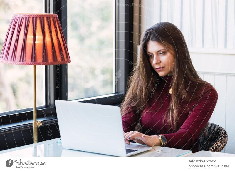 Frau arbeitet an einem Laptop in einem Cafe benutzend Café abgelegen freiberuflich Arbeit online Telearbeit digital modern ernst jung Apparatur Browsen Gerät