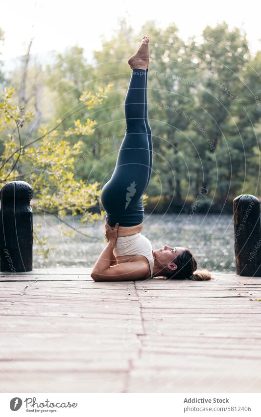 Frau in Sportkleidung macht Yoga in der Natur in der Nähe eines Sees Gesundheit Übung Lifestyle Fitness Körper Training Kaukasier Sportbekleidung Pilates jung