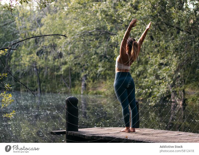 Frau in Sportkleidung macht Yoga im Freien in der Nähe eines Sees Gesundheit Übung Lifestyle Fitness Körper Training Kaukasier Sportbekleidung Pilates jung