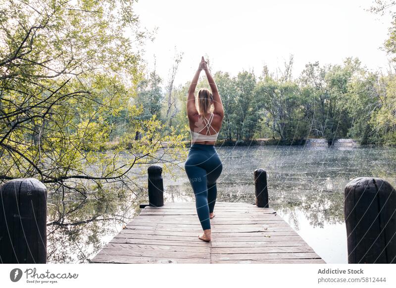 Frau in Sportkleidung macht Yoga in der Natur in der Nähe eines Sees Gesundheit Übung Lifestyle Fitness Körper Training Kaukasier Sportbekleidung Pilates jung