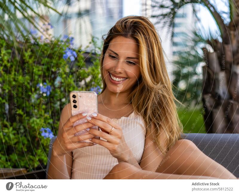 Nahaufnahme einer schönen Frau, die auf einem Sofa sitzt, während sie eine Nachricht auf ihrem Smartphone verfasst. schöne Menschen Erwachsener allein attraktiv