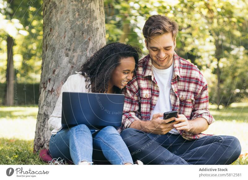Gemischtrassiges Paar studiert im Park mit Laptop rassenübergreifend Zusammensein Menschen jung Frau arbeiten Technik & Technologie modern zwei Lernen Schüler