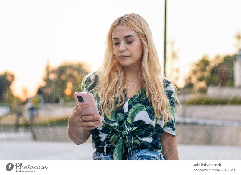 Blondes Mädchen benutzt Mobiltelefon im Freien Glück jung Sommer Frau Menschen Freizeit Lifestyle freudig Freude Blick Frühling Genuss Behaarung Großstadt cool