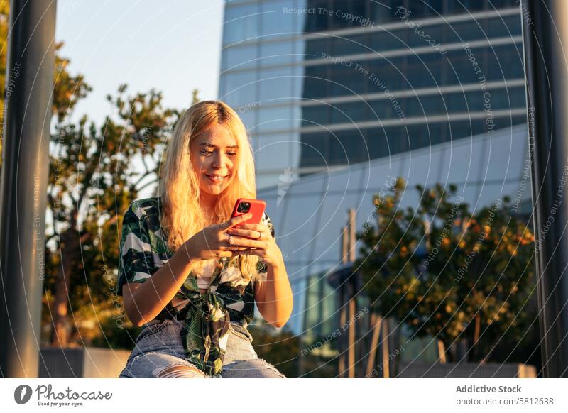 Blondes Mädchen benutzt Mobiltelefon im Freien Glück jung Sommer Frau Menschen Freizeit Lifestyle freudig Freude Blick Frühling Genuss Behaarung Großstadt cool