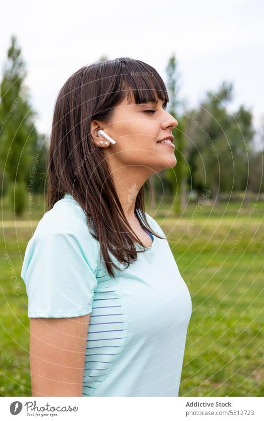Läuferin hört entspannt Musik beim Training im Freien aktiv Sportkleidung Erwachsener Athlet sportlich Körper Pause Atmung Windstille Kaukasier Kopfhörer