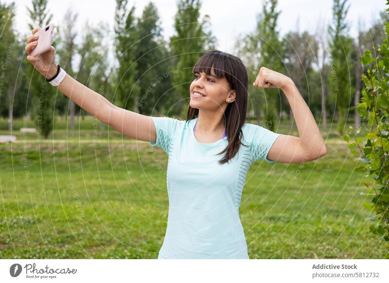 Sportliche Frau macht ein Selfie beim Fitnesstraining im Freien Erwachsener Athlet sportlich Bizeps Körper Herz selbstbewusst Übung trainiert. passen Mädchen