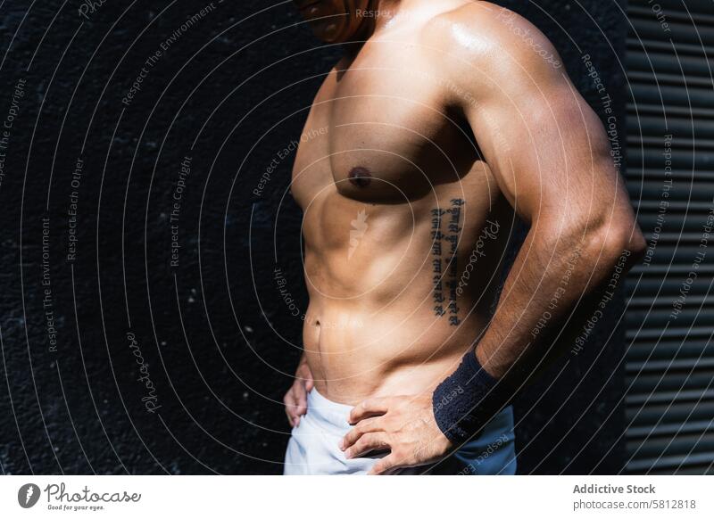 Anonymer positiver hispanischer Sportler ohne Hemd an der Wand Mann Training Gesunder Lebensstil Wellness Fitness muskulös nackter Torso Straße männlich