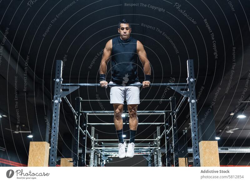 Hispanischer Sportler beim Training an der Latte Querbalken Fitnessstudio Übung Gesunder Lebensstil üben Herausforderung sportlich Mann Sportkleidung