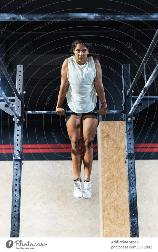 Hispanische Sportlerin beim Training an der Latte Querbalken Fitnessstudio Übung Gesunder Lebensstil üben Herausforderung sportlich Frau Sportkleidung