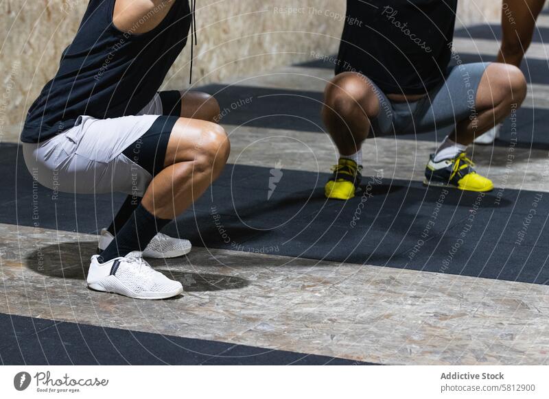 Sportler machen Kniebeugen beim Training im Sportverein Übung Zusammensein Aktivität Fitnessstudio Wohlbefinden Gesunder Lebensstil Athlet Sportbekleidung stark