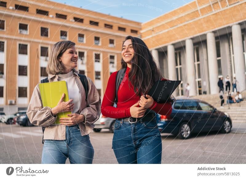zwei Studentinnen verlassen die Klasse Mädchen verlassend Schüler Universität Schule jung Glück Bildung Tasche Rucksack außerhalb Gebäude freudig Rücken