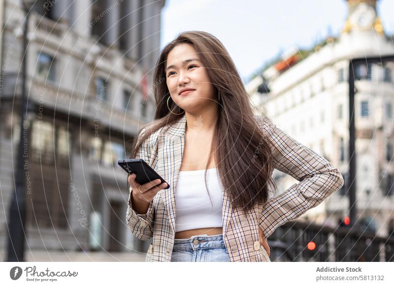 Junge asiatische Frau beim Spazierengehen und mit Smartphone in der Stadt Menschen Straße Großstadt jung Glück Lifestyle laufen Spaß im Freien Frauen urban