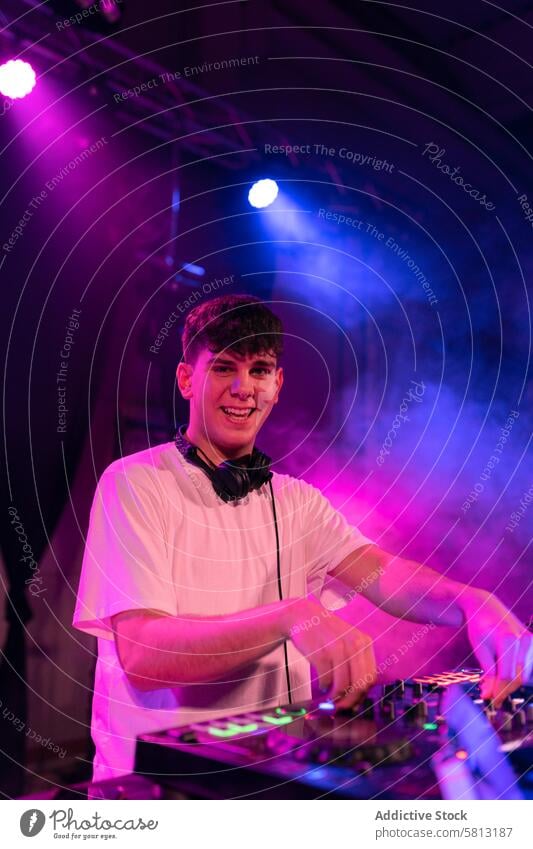 Porträt eines glücklichen DJs, der bei der Arbeit in die Kamera lächelt vertikal Mann dj jung Kaukasier Schauplatz Nachtclub Club Disco Lächeln