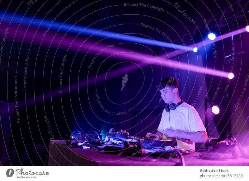 Konzentrierter DJ in einem Nachtclub Textfreiraum dj Mann Jugend Kaukasier ausführen Club Disco Arbeit Licht neonfarbig Lebensstile Entertainment Künste