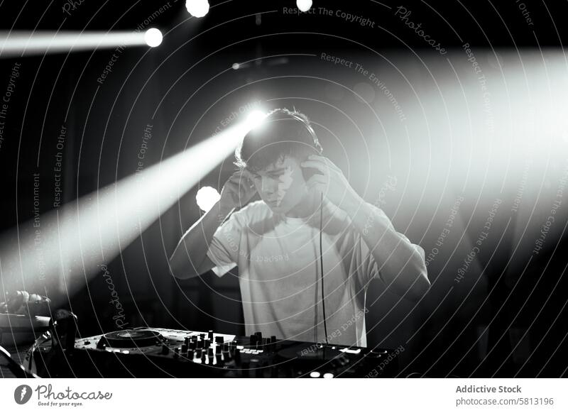 Ungesättigtes Foto eines Discjockeys an den Plattentellern schwarz auf weiß ungesättigt dj Menschen Mann jung Kaukasier Diskjockey Schauplatz berühren