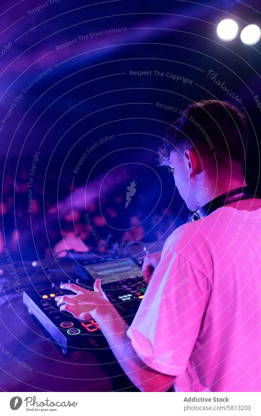 Ein DJ mischt auf der Bühne mit einem Brett vertikal Rückansicht jung Kaukasier dj Schauplatz Holzplatte mischen Musik Licht Beruf Party purpur