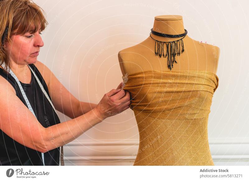 Modedesignerin steckt Nadeln in den Stoff einer Schaufensterpuppe 50s Geschäftsperson Erwachsener Geschäftsfrau Bekleidung Selbstvertrauen selbstbewusst