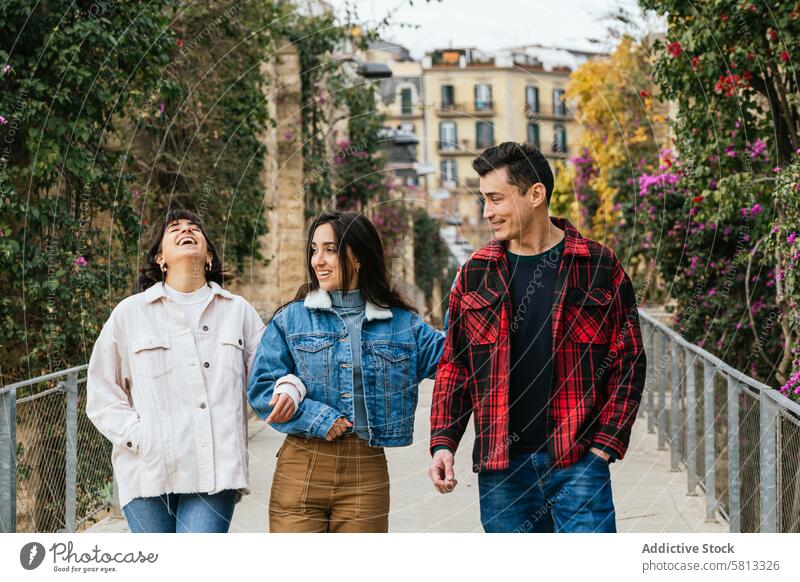 Freunde bei einem gemütlichen Spaziergang im Freien Brücke lachen Freude Freizeit urban Grün lässig Bekleidung Jeanshose Jacken Unternehmen