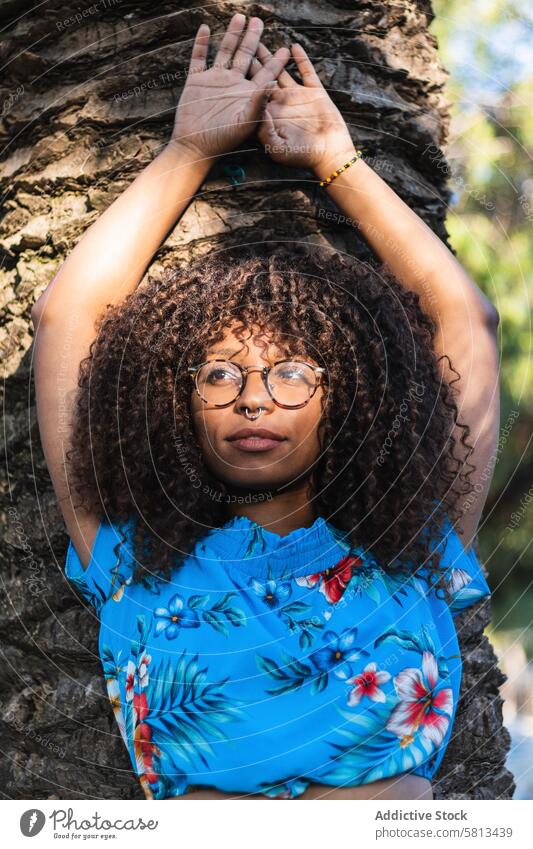 Trendy African American Frau in der Nähe von Palmen Handfläche Kofferraum Stil fettarm Sommer Straße Vorschein jung Urlaub krause Haare trendy