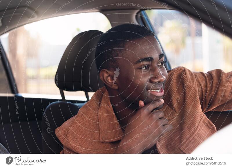 Fröhlicher schwarzer Mann im Auto PKW Fahrer Automobil Laufwerk Lächeln Arbeitsweg Vorschein Fenster Straße Lenkrad positiv Afroamerikaner Verkehr modern