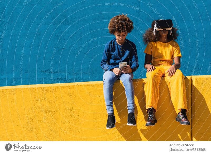 Schwarze Teenager nutzen moderne Gadgets Kind Apparatur Smartphone VR Headset Virtuelle Realität benutzend Zusammensein Afroamerikaner Afro-Look schwarz