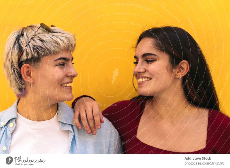 zwei lächelnde Teenager-Mädchen, die sich gegenseitig anschauen Lächeln Haardochte Freundschaft Frau jung Kurze Haare schön heiter Textfreiraum Glück Blick