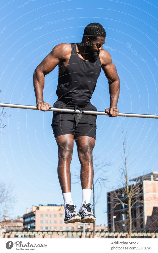 Starker schwarzer Sportler beim Training an der Bar in der Stadt hochziehen Übung muskulös stark Mann Muskel Fitness Sportbekleidung Afroamerikaner Kraft