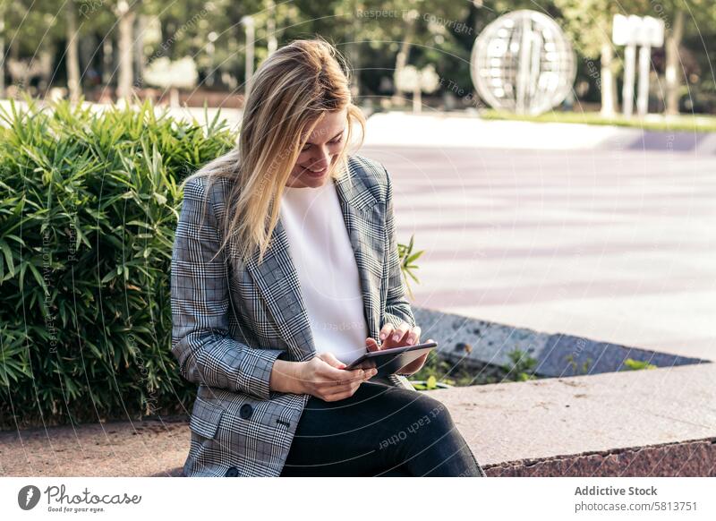 blonde Geschäftsfrau im Anzug, die draußen ein Tablet benutzt und lächelt Business Sitzung Team professionell Exekutive Erfolg Unternehmer Finanzen korporativ