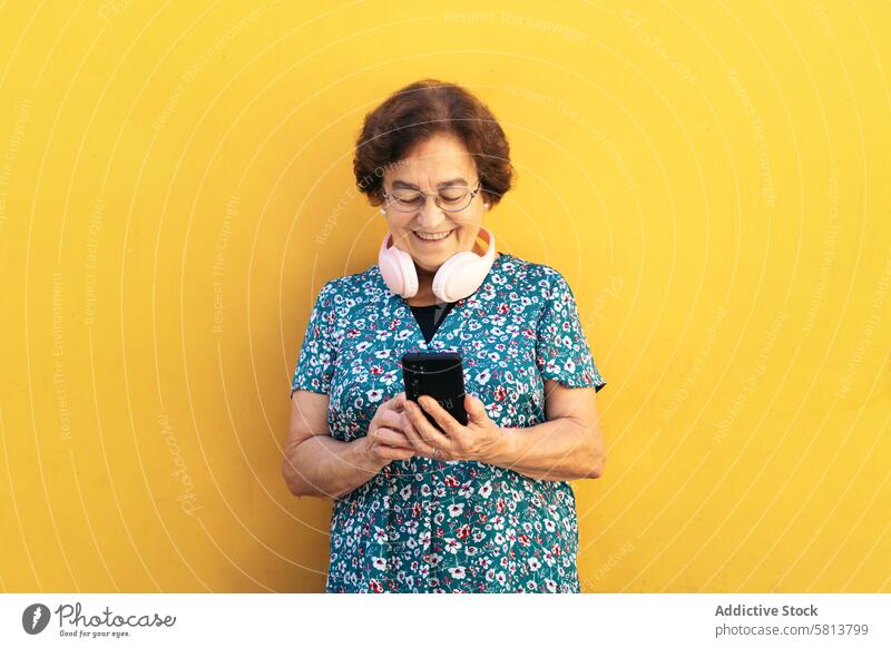 Lächelnde alte Frau benutzt Smartphone im Freien stylisch Mobile Funktelefon Senior Mitteilung Gerät Nachricht Lifestyle Internet Handy Menschen Geschäftsfrau
