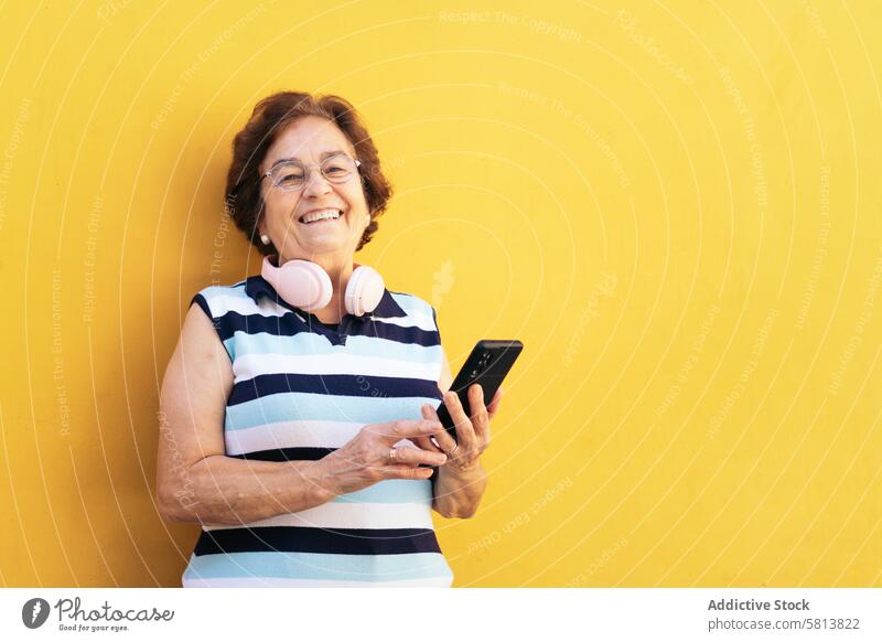 Lächelnde alte Frau benutzt Smartphone im Freien stylisch Mobile Funktelefon Senior Mitteilung Gerät Nachricht Lifestyle Internet Handy Menschen Geschäftsfrau