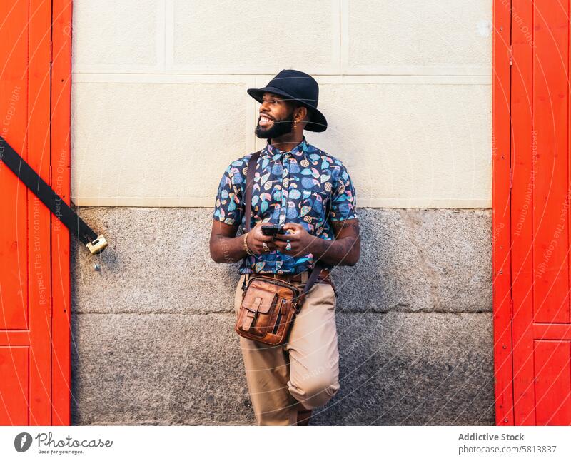 Stilvoller schwarzer Mann, der sein Smartphone im Freien in der Stadt benutzt Technik & Technologie Lifestyle Großstadt jung Straße urban Telefon Mobile