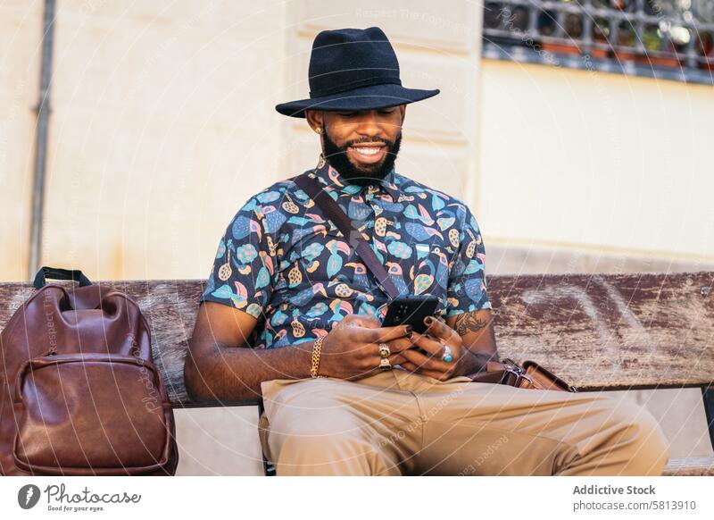 Stilvoller schwarzer Mann auf der Straße in der Stadt mit Smartphone Technik & Technologie Lifestyle Großstadt jung urban Telefon Mobile männlich Person