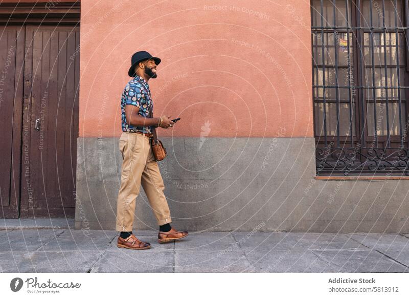 Stilvoller schwarzer Mann auf der Straße mit Smartphone Technik & Technologie Lifestyle Großstadt jung urban Telefon Mobile männlich Person benutzend