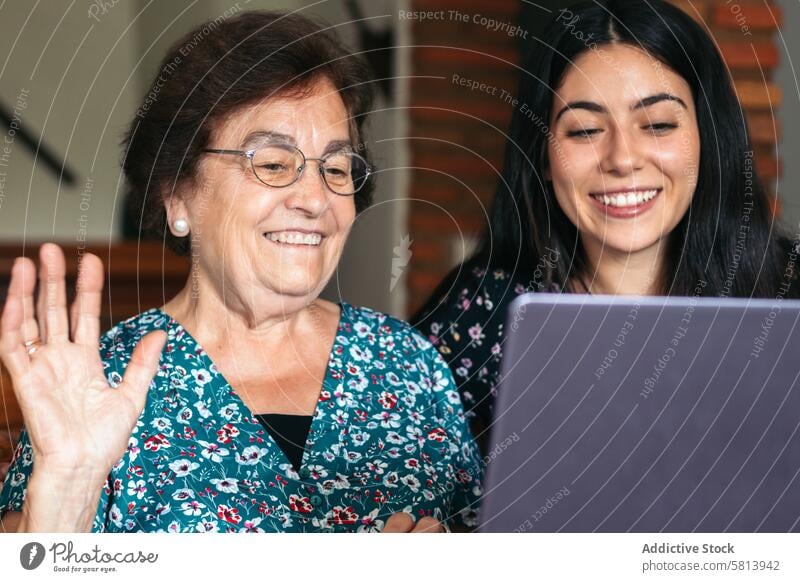 Großmutter und Enkelin führen einen Videoanruf mit dem Laptop zu Hause Internet Familie Computer heimwärts online Senior alt Technik & Technologie Mädchen Glück