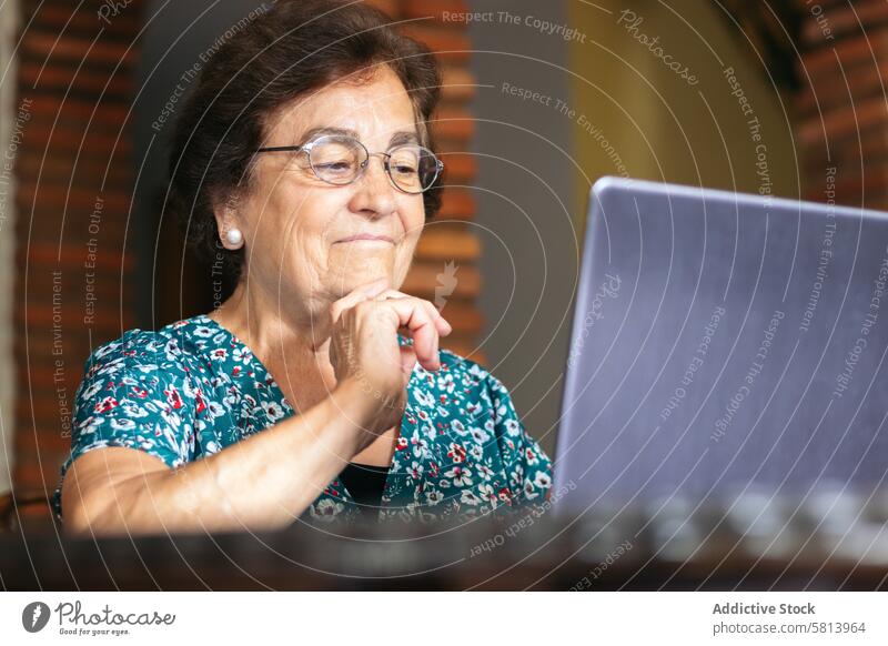 Ältere Frau mit Brille benutzt zu Hause einen Laptop Senior Technik & Technologie Computer reif Glück heimwärts Internet Person Menschen Sitzen Lifestyle