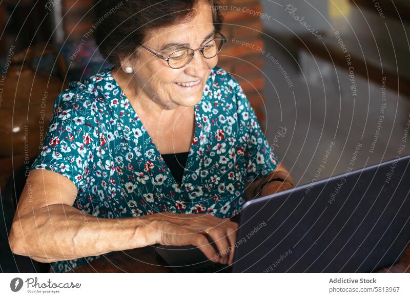 Ältere Frau mit Brille benutzt zu Hause einen Laptop Senior Technik & Technologie Computer reif Glück heimwärts Internet Person Menschen Sitzen Lifestyle