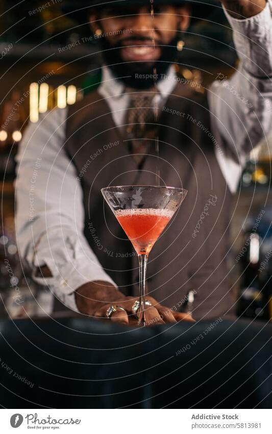 Schwarzer Barkeeper bei der Zubereitung eines Cocktails in einer traditionellen Cocktailbar Barmann Getränk Mixologe Nachtclub schwarz Alkohol Glas trinken