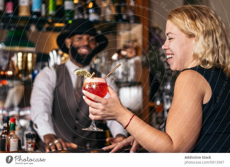 Stilvolle schwarze Barkeeperin bietet einem Kunden einen Cocktail an Barmann Getränk Cocktailbar Mixologe Nachtclub Alkohol Glas trinken Arbeit professionell