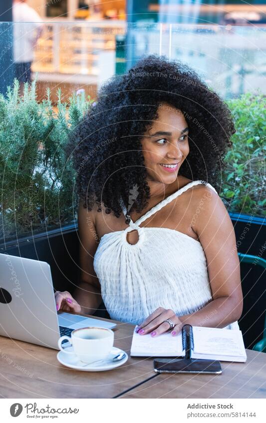 Lächelnde schwarze Frau arbeitet an einem Laptop in einem Café schwanger abgelegen benutzend freiberuflich Notebook Kaffee Arbeit positiv mütterlich Telearbeit