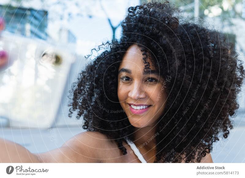 Glückliche schwarze Frau mit lockigem Haar, die ihre Hand in die Kamera hält positiv Vorschein angenehm Porträt sorgenfrei Glee charmant Persönlichkeit