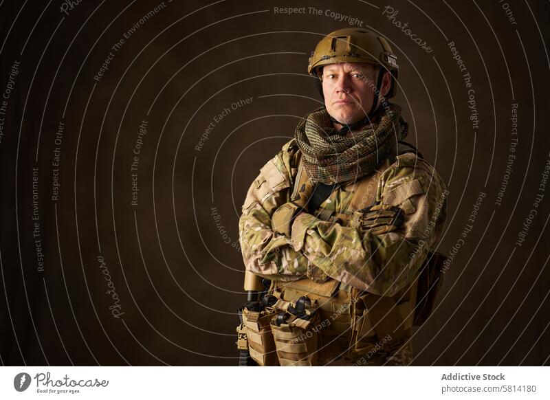 Ein junger männlicher Militärsoldat posiert mit einem automatischen Airsoft-Gewehr mit Zielfernrohr Mann Outfit Genuss Hobbys Simulation Spiel Soldat ausfahrbar