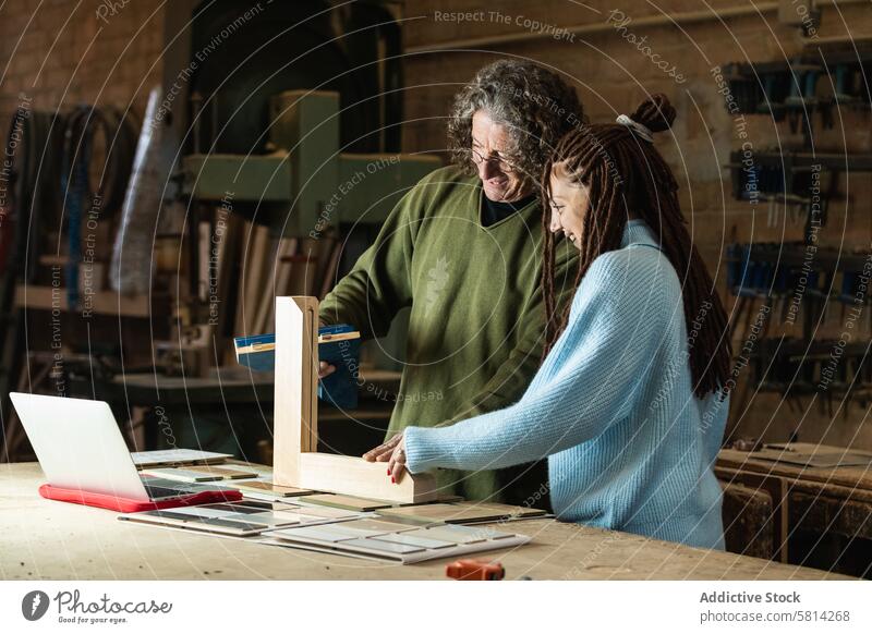 Schreiner bei der Herstellung eines Holzrahmens im Gespräch mit einem Kunden Mann Frau Zimmerer Hobelbank Orden hölzern Detailaufnahme diskutieren Holzarbeiten