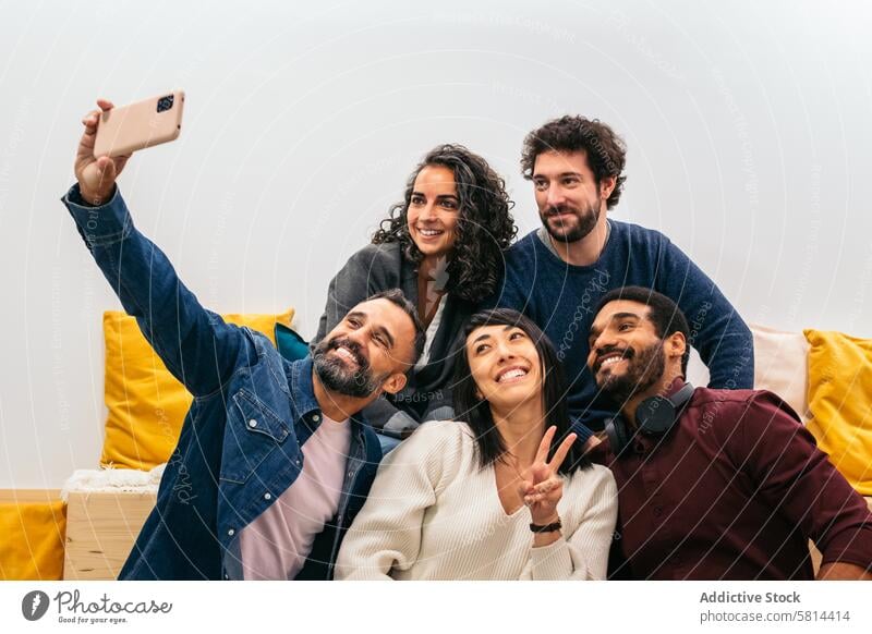 Multirassische glückliche Mitarbeiter machen ein Selfie mit Smartphone im Pausenraum eines modernen Coworking-Büros Inbetriebnahme Moderner Arbeitsbereich