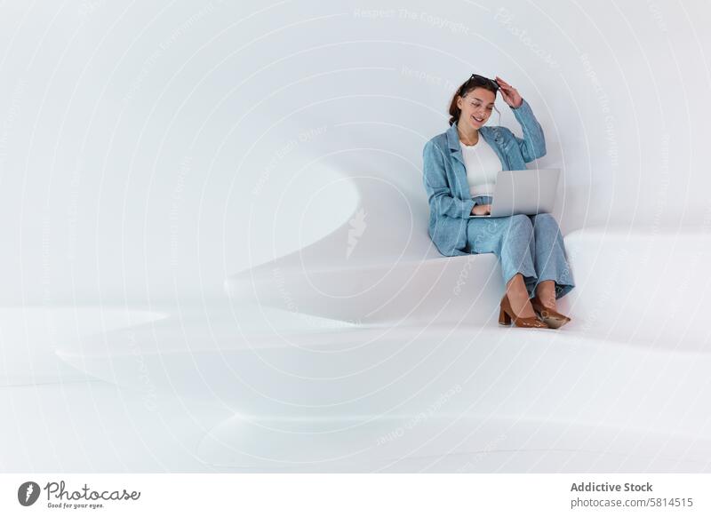 Frau beim Surfen auf dem Laptop Browsen online Atelier modern Design Apparatur benutzend Gerät Netbook elegant Wand Anschluss Stil feminin Outfit trendy Anzug